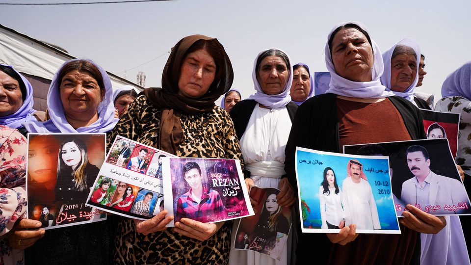 August 1, 2025, Zakho, Iraq: Iraqi Yazidi women hold pictures of their victims and missing relatives during a ceremony at Chamishko camp for Yazidi IDPs